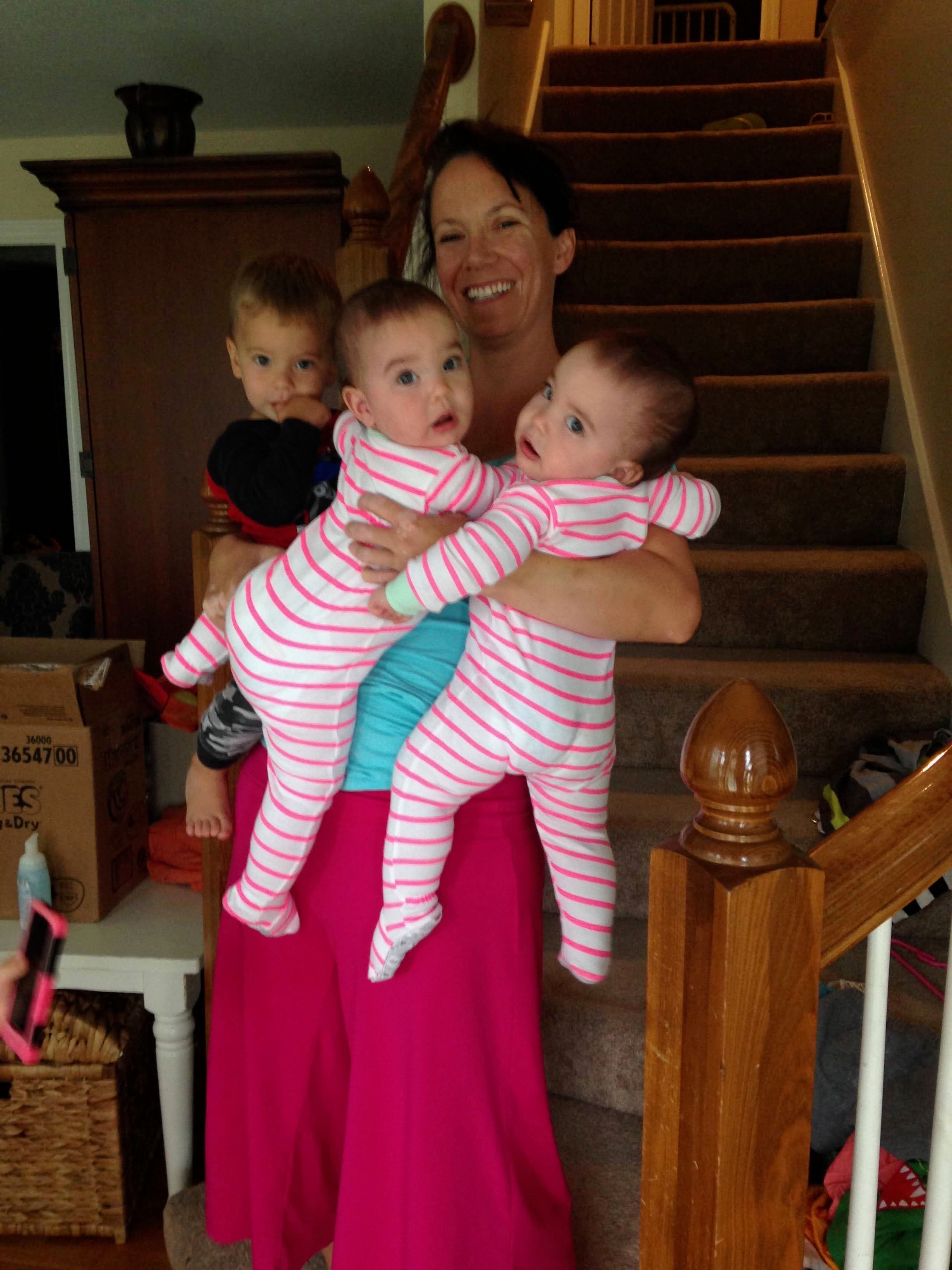 Meg Miller carrying three of her young children